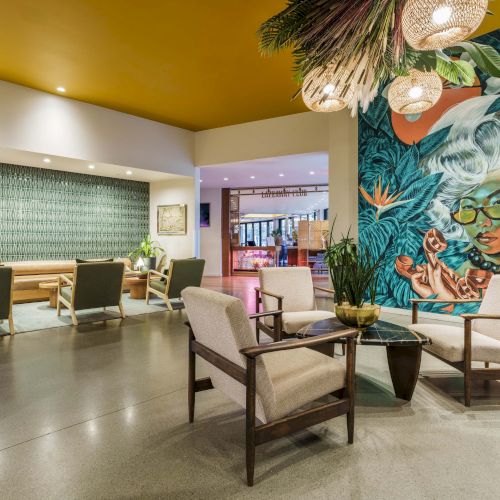 A bright, whimsical children's playroom with colorful murals, beanbags, a teepee, cozy seating, and playful wall art, inviting imaginative fun.