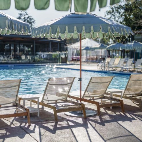 A sunny poolside scene with lounge chairs, a shaded cabana area, and a clear blue pool.

Top it at 140 characters, always ending the sentence.