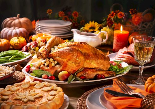 A festive Thanksgiving spread with a roast turkey, pie, vegetables, and wine, surrounded by autumn decorations like pumpkins and candles.